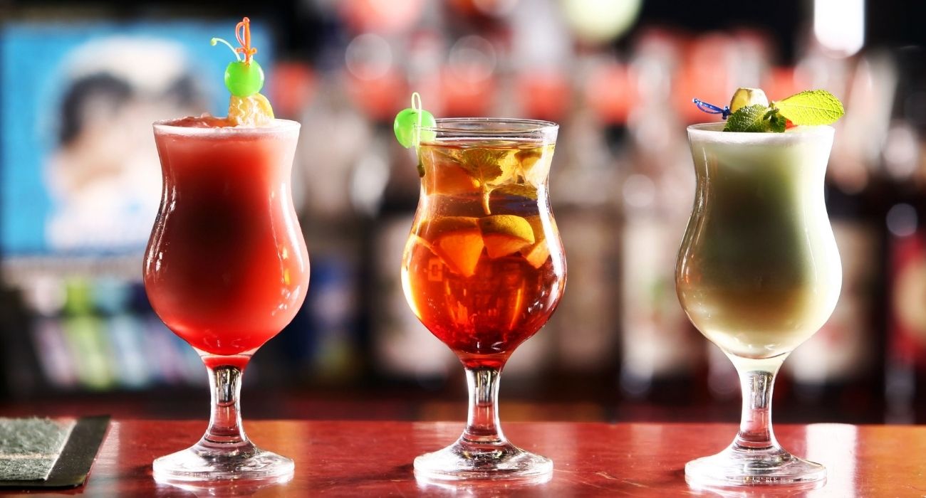 three cocktail drinks on a bar