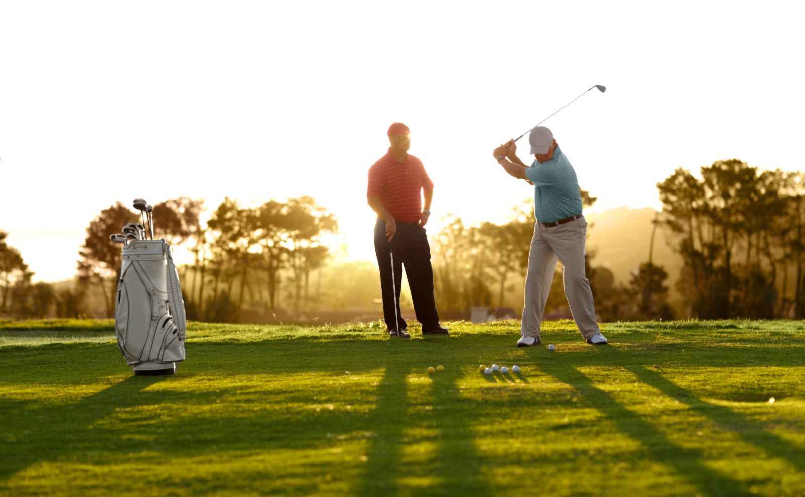 two men golfing in the morning light